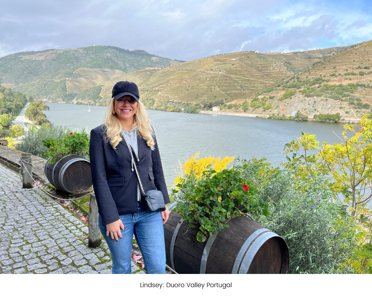 A woman carrying black chain purse standing by scenic water views