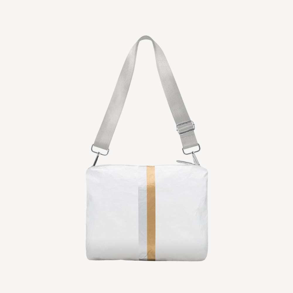 White crossbody bag with a gold and silver stripe on a white background