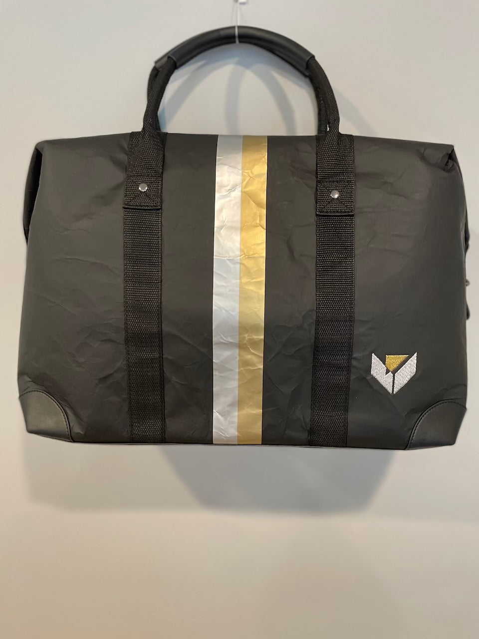 Weekender duffle bag black with silver gold stripes with a custom logo on a white background.