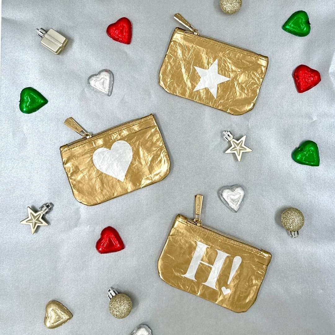 Gold pouches with decorative elements on a light gray background