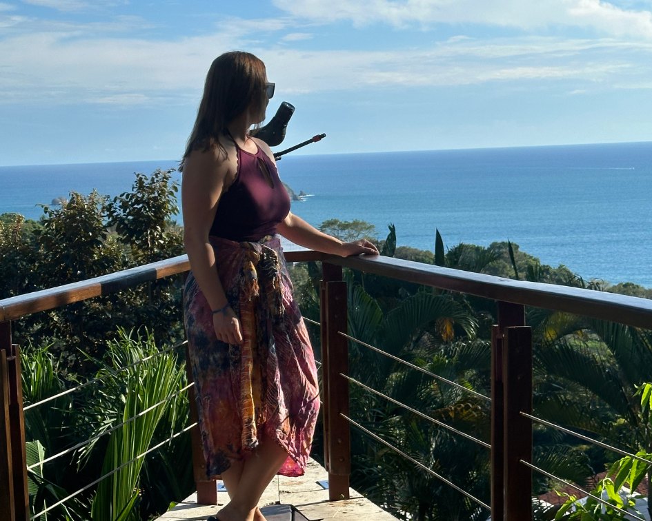 Woman in burgundy top and patterned skirt looking at the ocean in Manuel Antonio Costa Rica