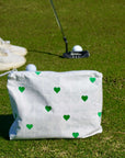White pouch with white golf balls and green hearts on a golf course
