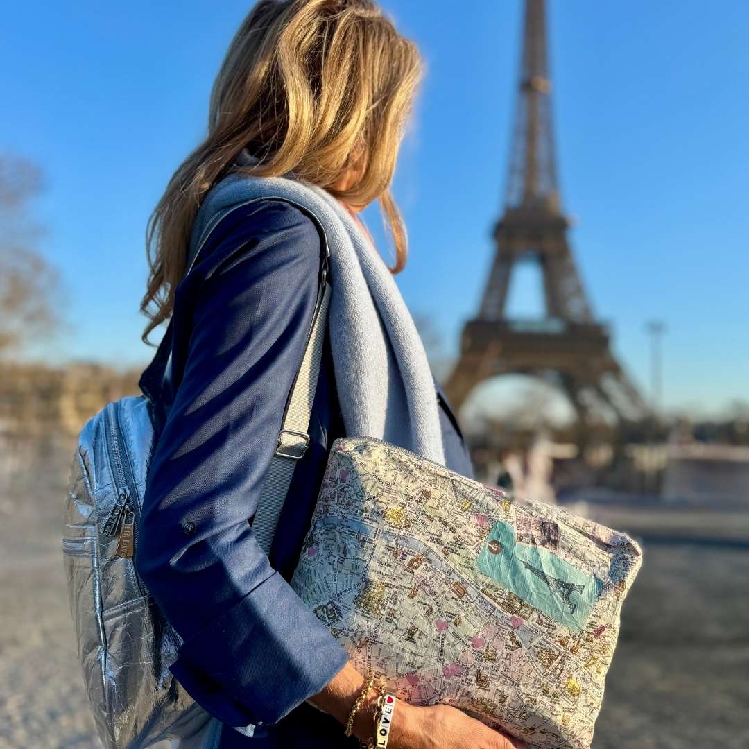 Person holding a paris bag map with the Eiffel Tower in the background