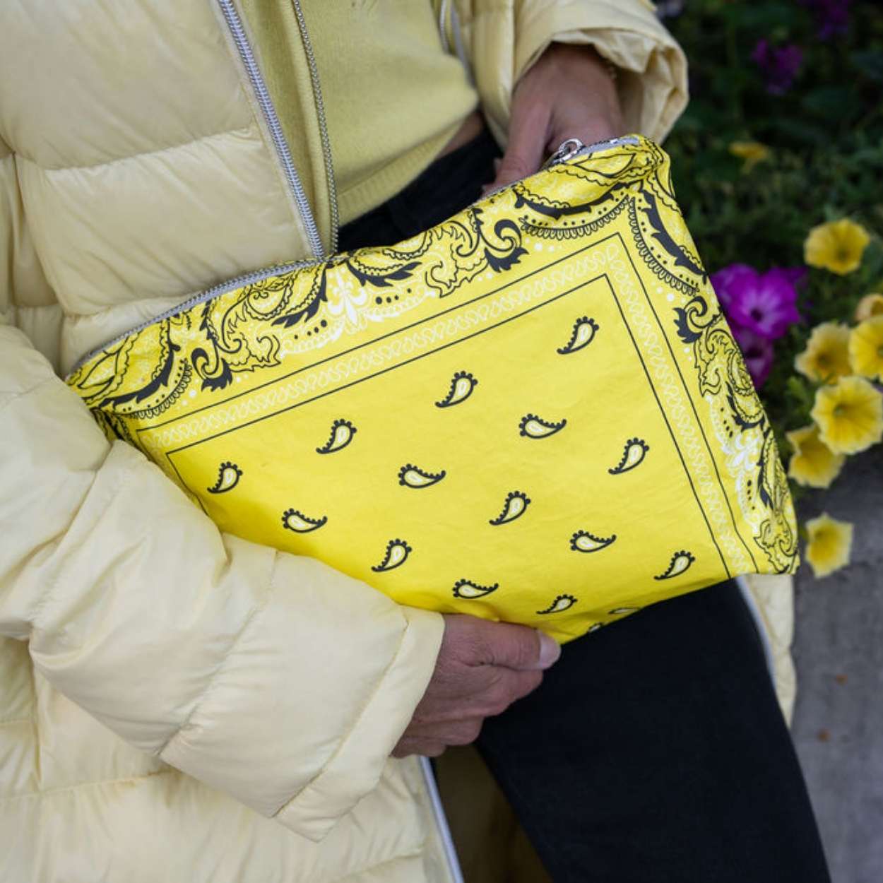 Person in yellow jacket holding medium zipper pouch in yellow bandana print