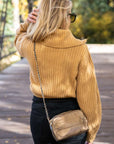 Person walking outdoors wearing mini puffer chain purse in shimmer bronze