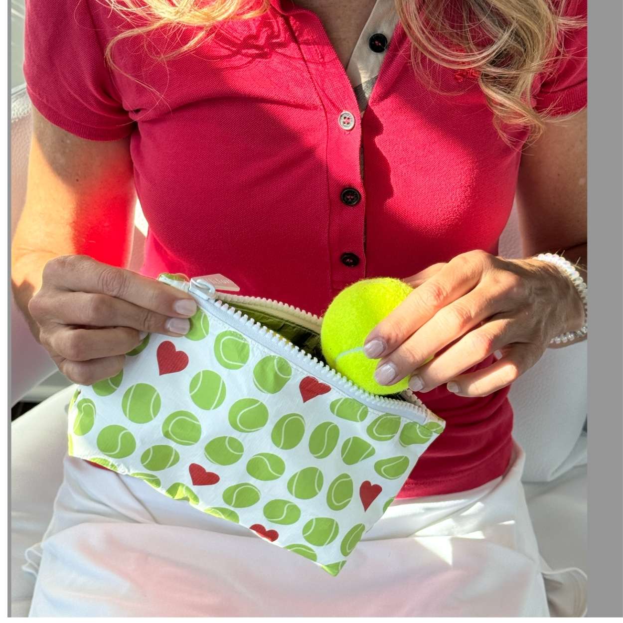 Small zipper pouch with tennis balls and heart print.