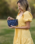 Woman carrying mini navy with silver stars zipper Pouch