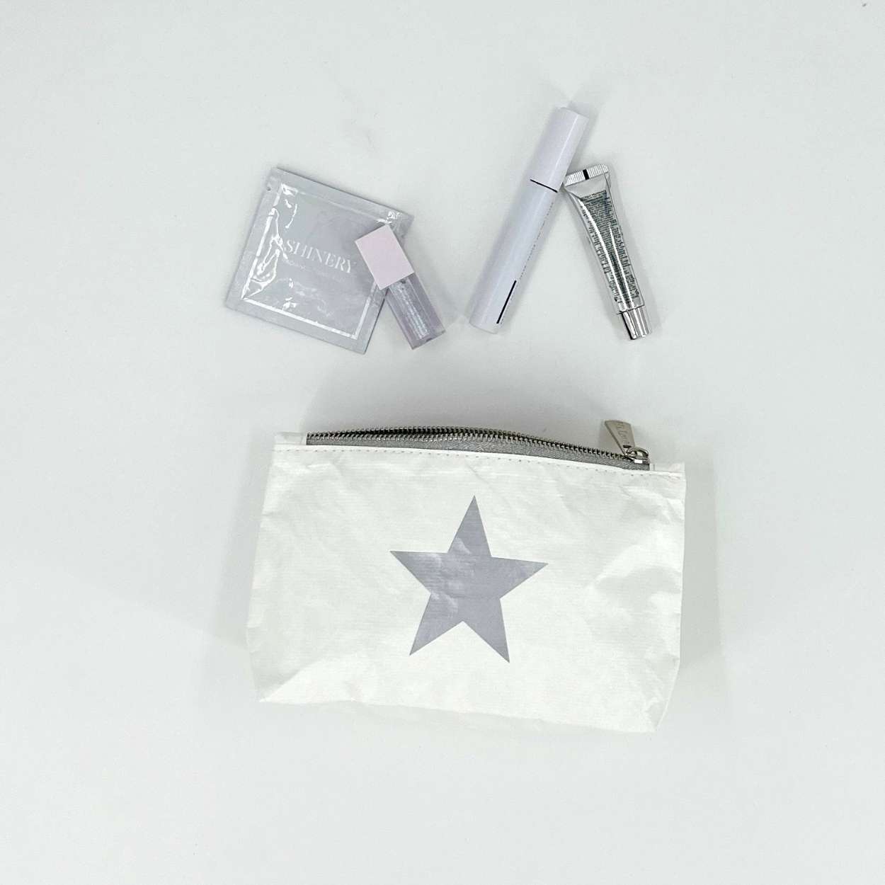 Small zipper pouch in white with silver star with makeup
