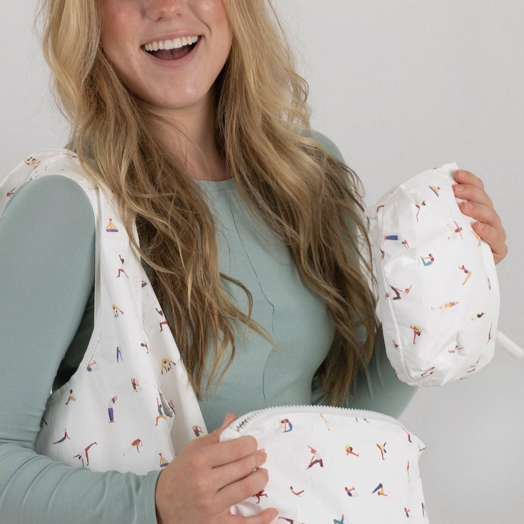 Woman holding small zipper pouch with yoga pose print