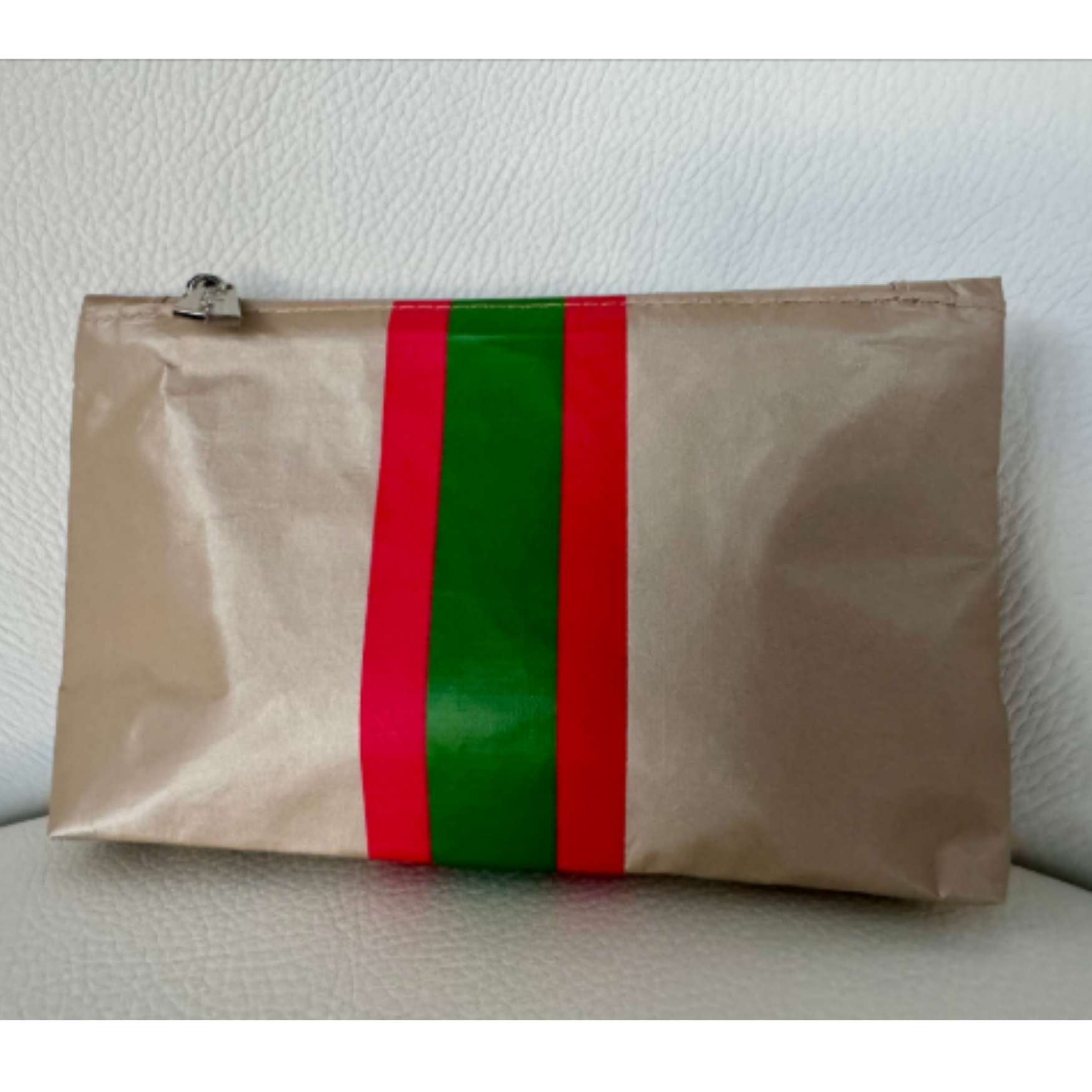 Mini shimmer beige pouch with green and red stripes in a white background