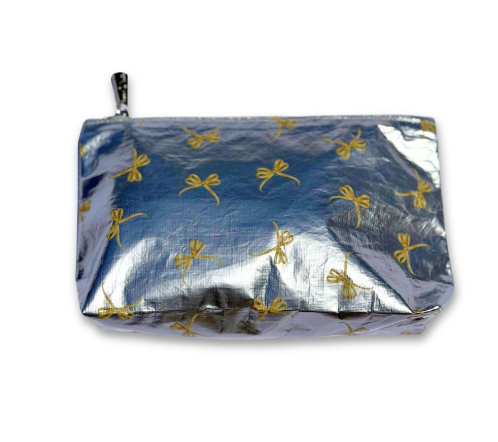 Silver metallic cosmetic pouch with golden bows and a top zipper.
