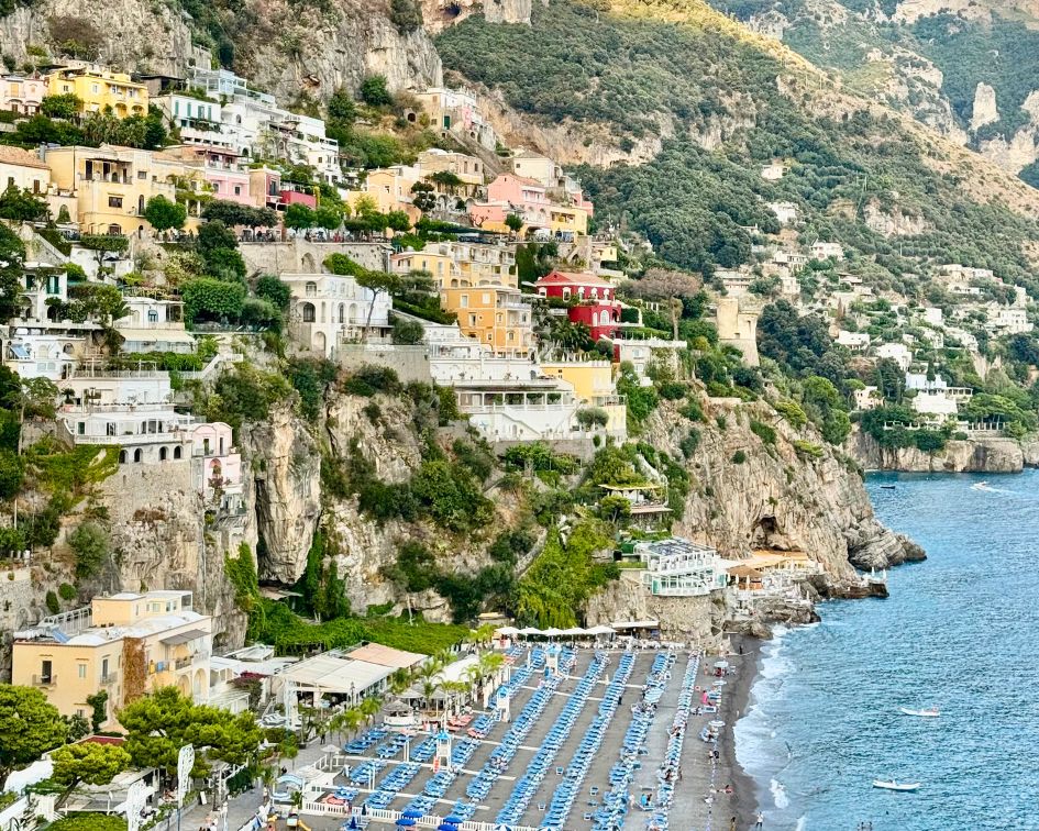 View of Positano, Italy beach with colorful buildings on the cliff.