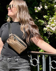 Woman wearing crossbody fanny pack belt bag in Shimmer Bronze Black Strap