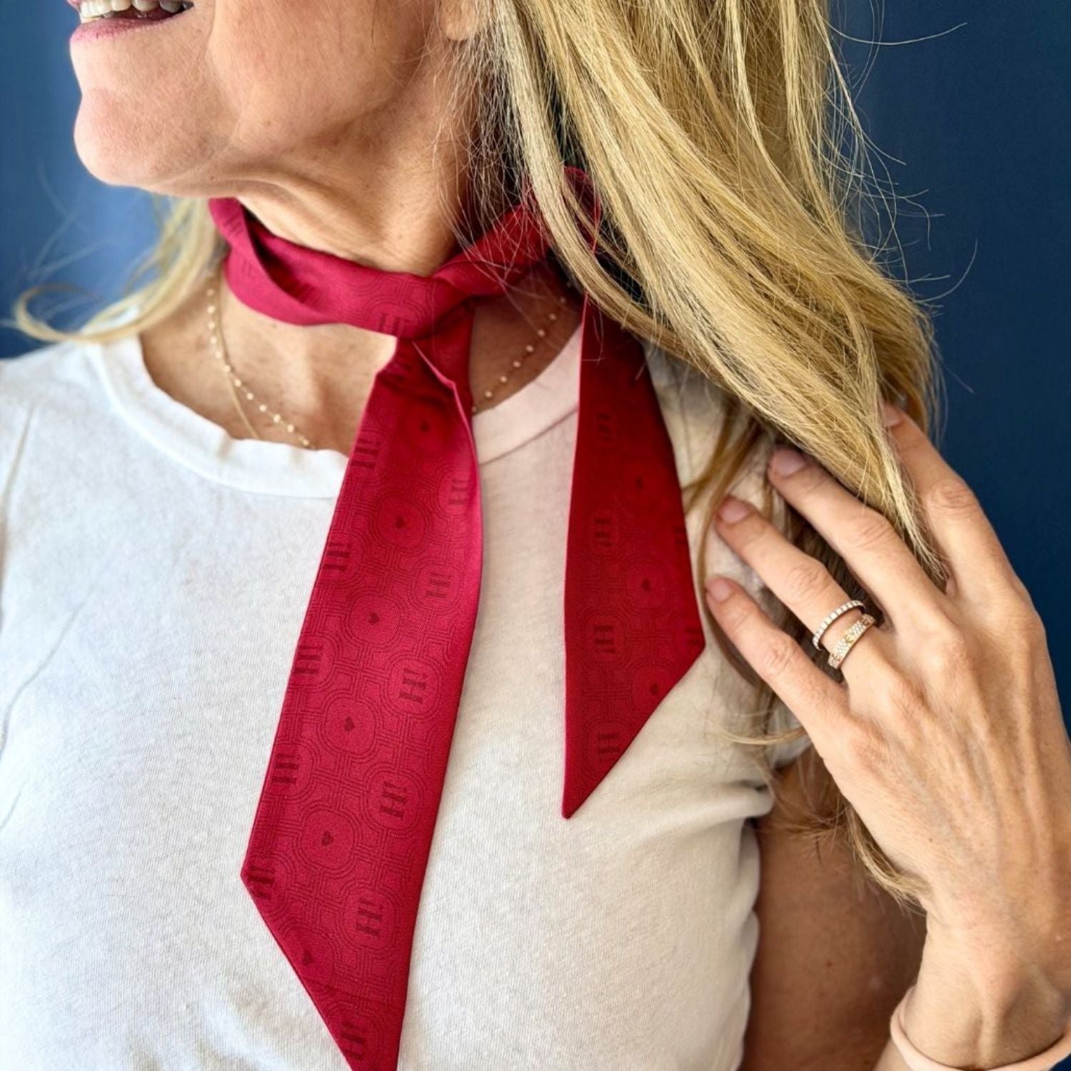 Women wearing a red tonal printed scarfette around her neck.