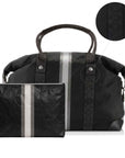 A black travel duffel bag with a matching zippered pouch, both featuring vertical pewter and silver stripes and signature black fabric panels, shown on a white background with a circular detail inset.