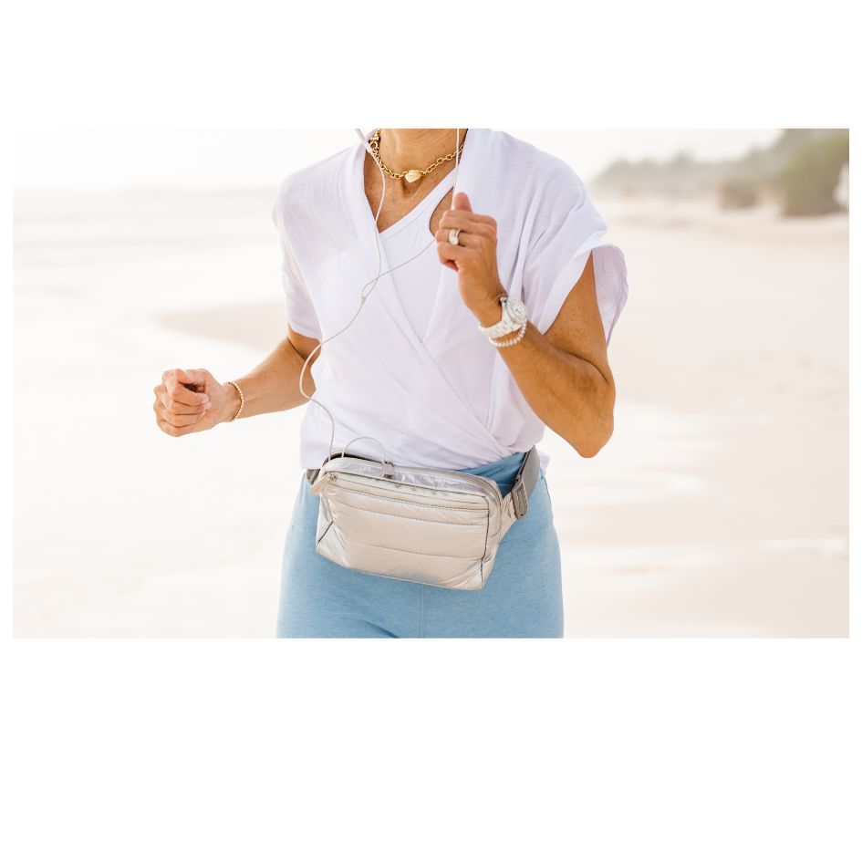 Woman Running Wearing Silver Puffer Crossbody Belt Bag Fanny Pack
