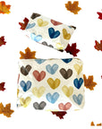 Two Pouches with colorful heart patterns on a white background with autumn leaves.