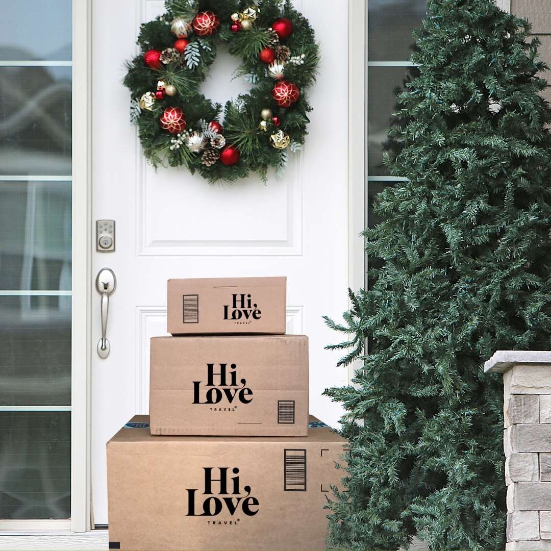 Decorative wreath on a door with 'Hi, Love' boxes and a Christmas tree.