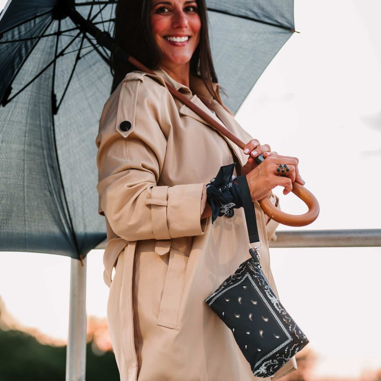 Women carrying umbrella with navy bandana print wristlet