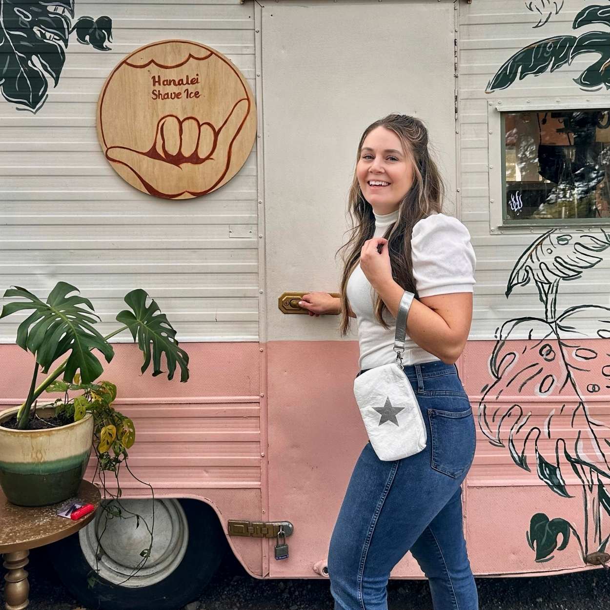 Woman carrying white with silver star wristlet