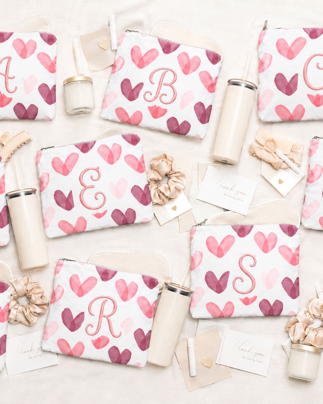 Set of pouches with heart patterns and embroidered custom initials on a light background