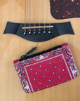 Red bandana-patterned pouch on an acoustic guitar