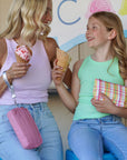 Mother and daughter eating ice cream cones with pink and plaid wristlet pouches