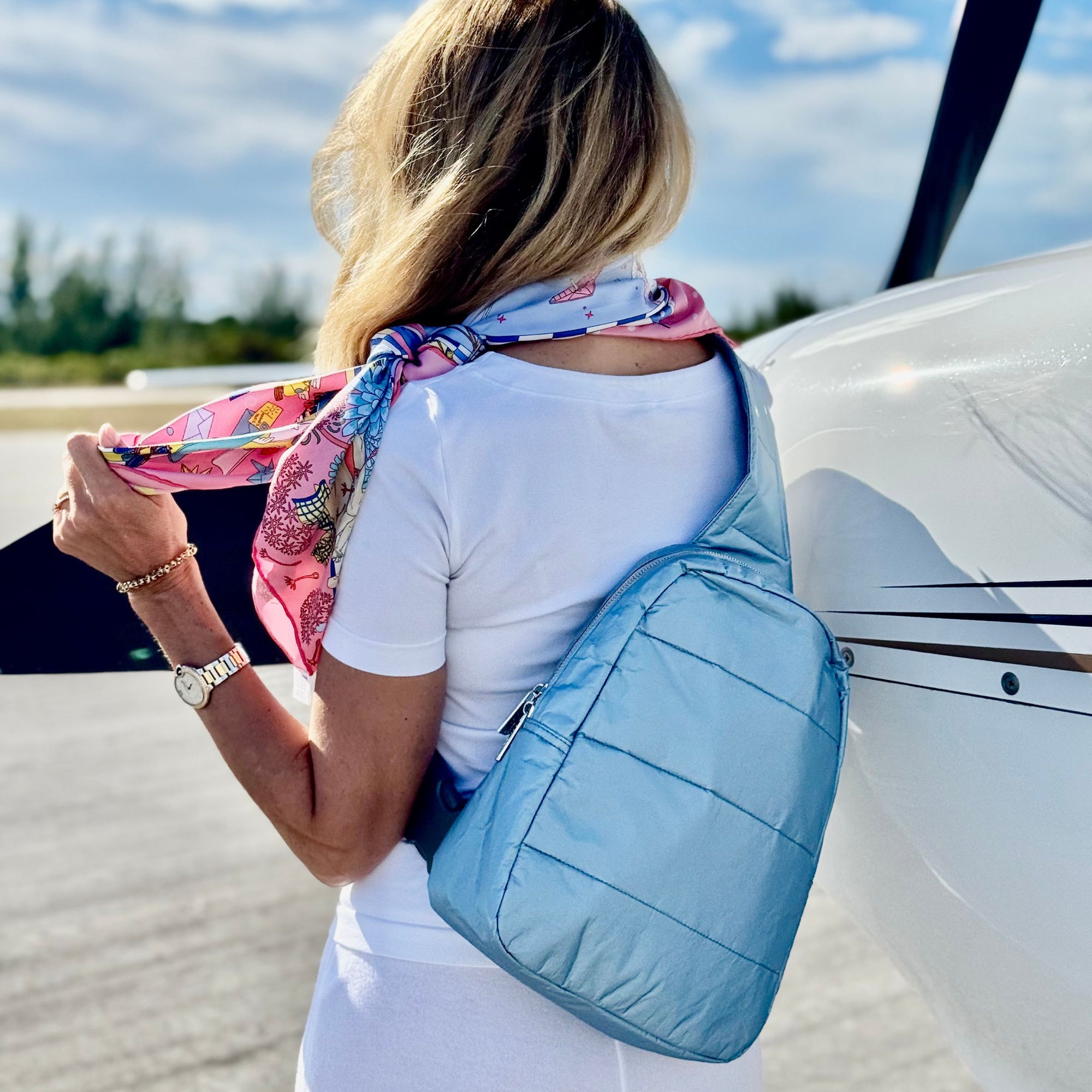 Woman outside wearing shimmer ice blue crossbody backpack