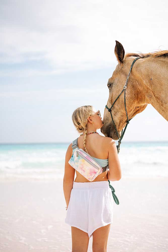 Girl with horse on beach wearing watercolor puffer crossbody fanny pack belt bag 