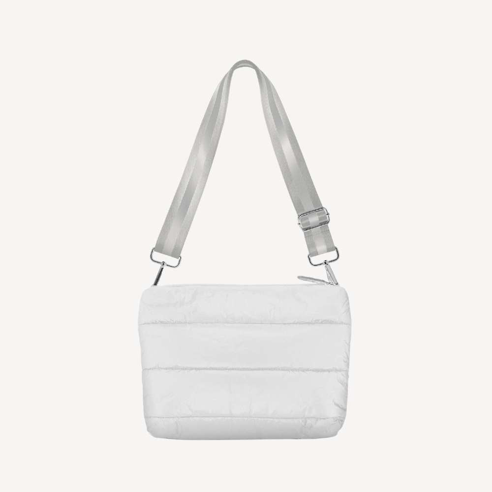 A crossbody bag that is shimmer white in color and puffer style with a gray strap on a white background.