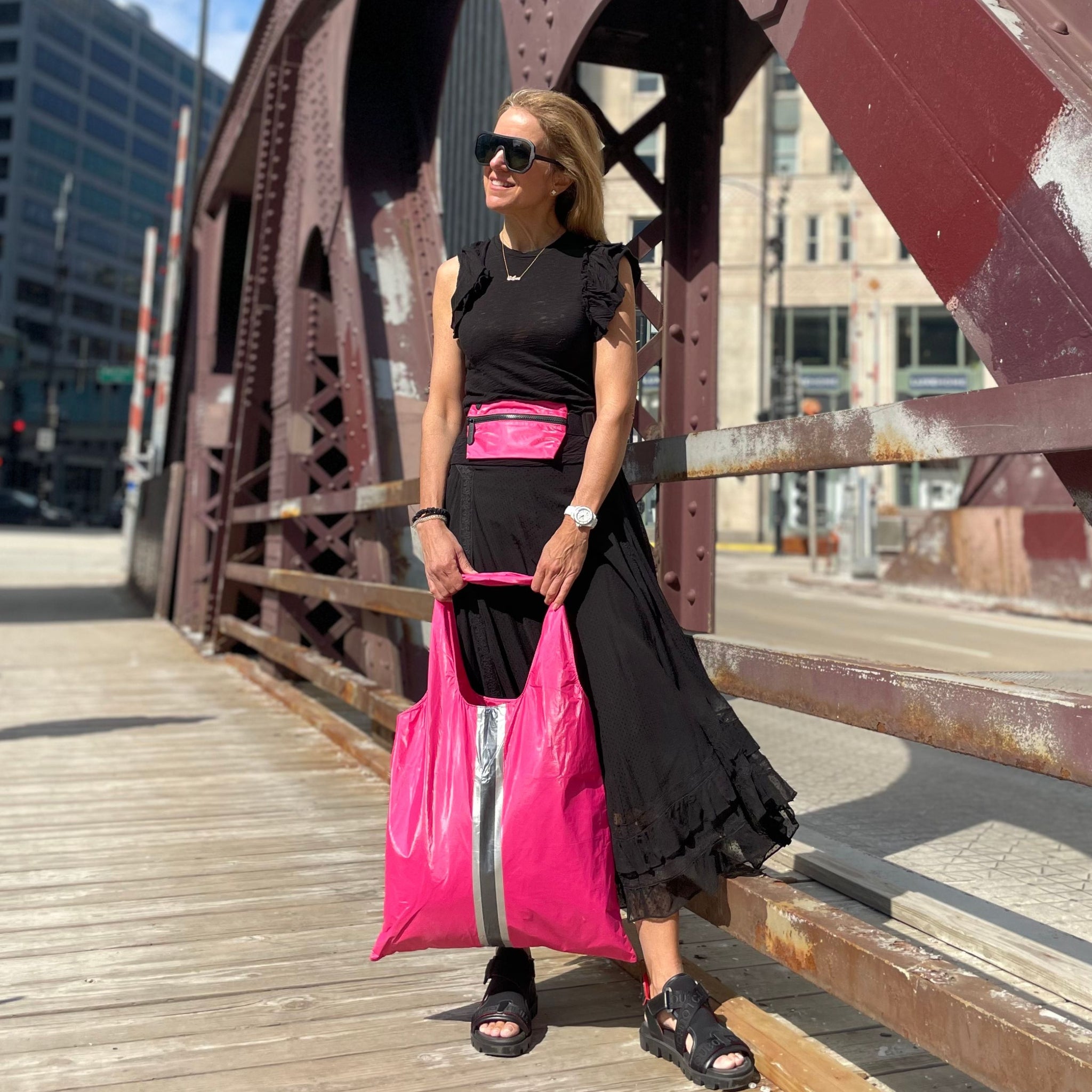Woman wearing hot pink fanny pack and holding hot pink tote bag