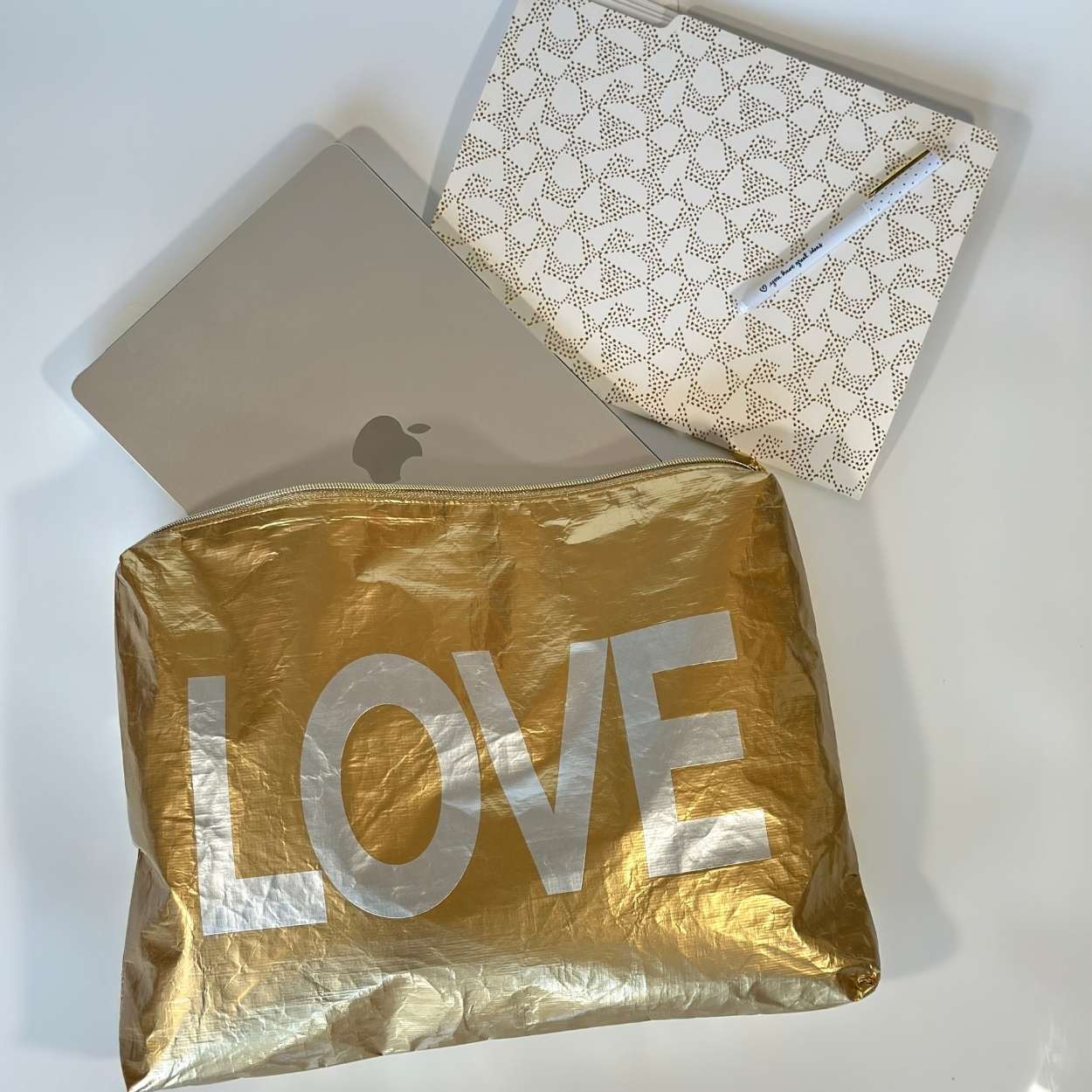 Computer in Jumbo zipper pouch in gold with silver LOVE on white background