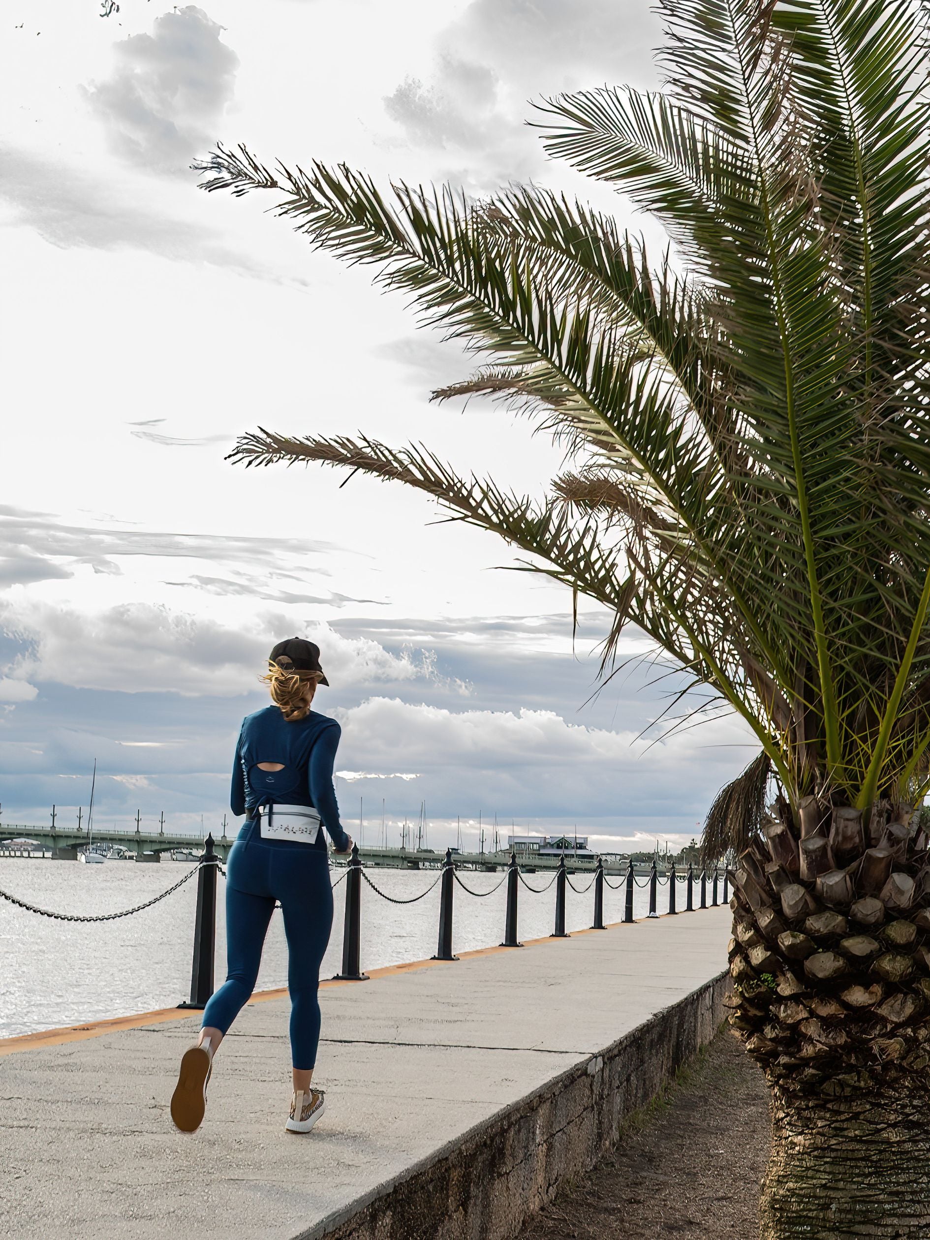 Woman running by the water wearing fanny pack