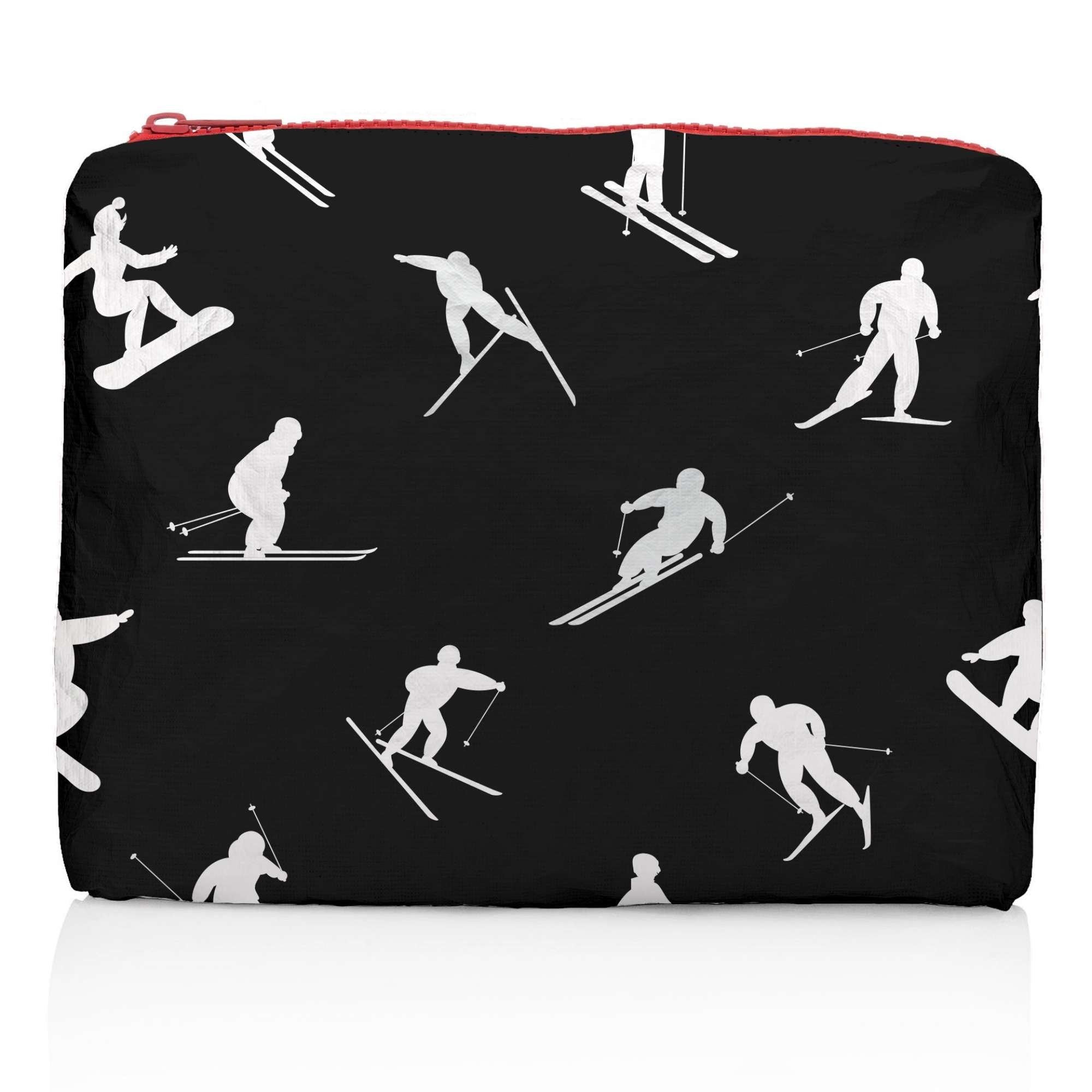 Medium Zipper Pouch Dancing Skiers II Black &amp; White featuring a black background with white skier silhouettes in motion and a contrasting red zipper on a white background.