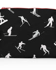 Medium Zipper Pouch Dancing Skiers II Black & White featuring a black background with white skier silhouettes in motion and a contrasting red zipper on a white background.