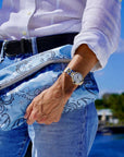 Person holding a blue bandana patterned bag with a scenic water background
