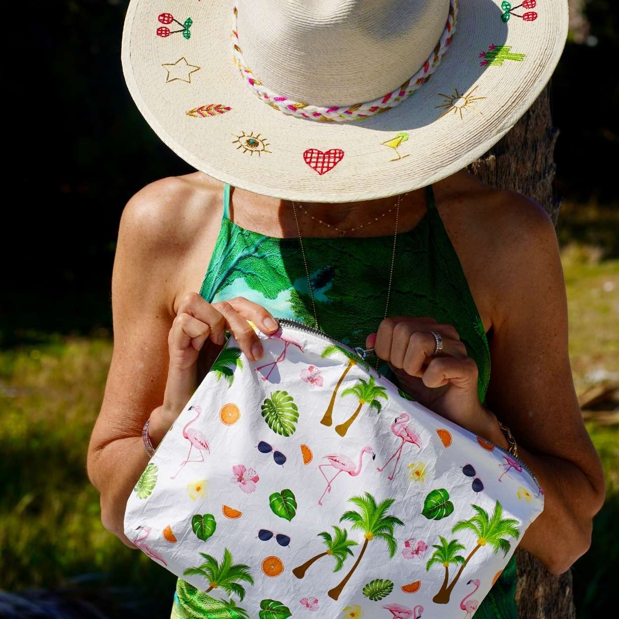 Person holding a pouch with tropical designs outdoors