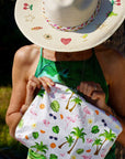 Person holding a pouch with tropical designs outdoors