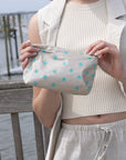 Woman holding mini zipper pouch beige with myriad green stars