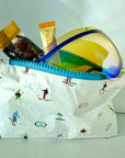 White mini zipper pouch with skiers and goggles pattern and ski goggles inside