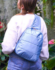 Woman outside wearing shimmer ice blue crossbody backpack