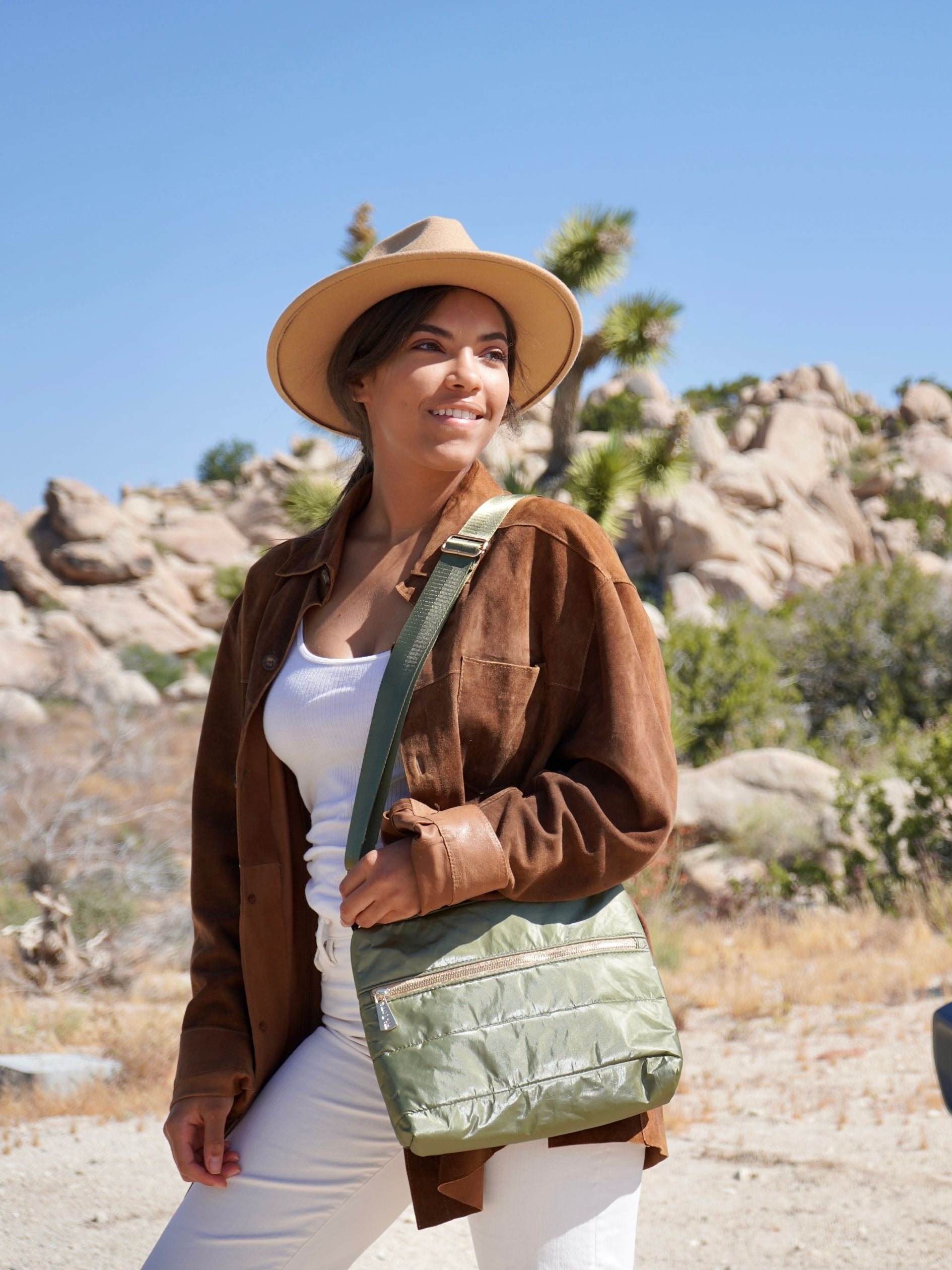 Woman wearing crossbody purse in army green in Joshua tree