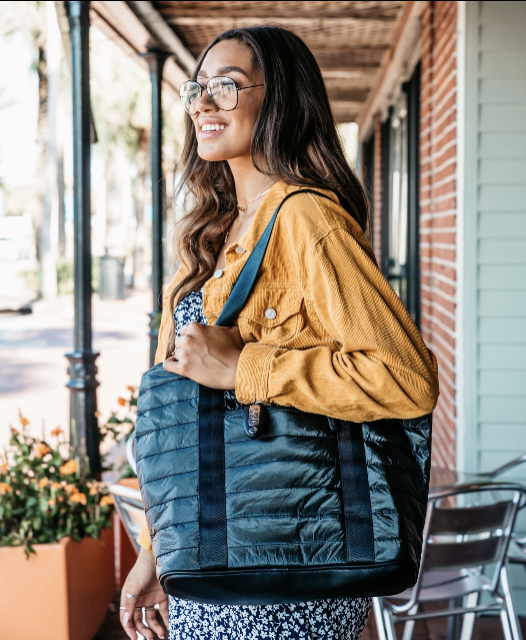 Woman wearing a Hi Love Travel Puffer Tote Bag in black over the shoulder, styled with a corduroy jacket for fall.
