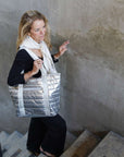 Woman holding a silver quilted bag in an indoor setting