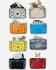 Eight small zip pouches or coin purses arranged in a grid on a light gray background. Each pouch has a different decorative bandana-style print in various colors, including black, beige, orange, blue, yellow, light blue, white, and red.