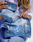 Person holding a blue bandana patterned bag with a white background