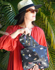 Woman holding a butterfly-patterned pouch against a green leafy background
