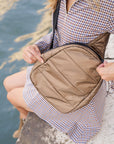 Woman in checkered dress wearing shimmer bronze crossbody backpack