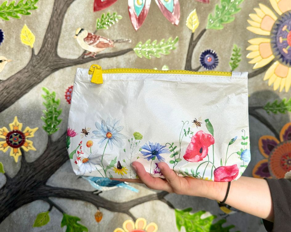 White pouch with spring flowers with floral mural background