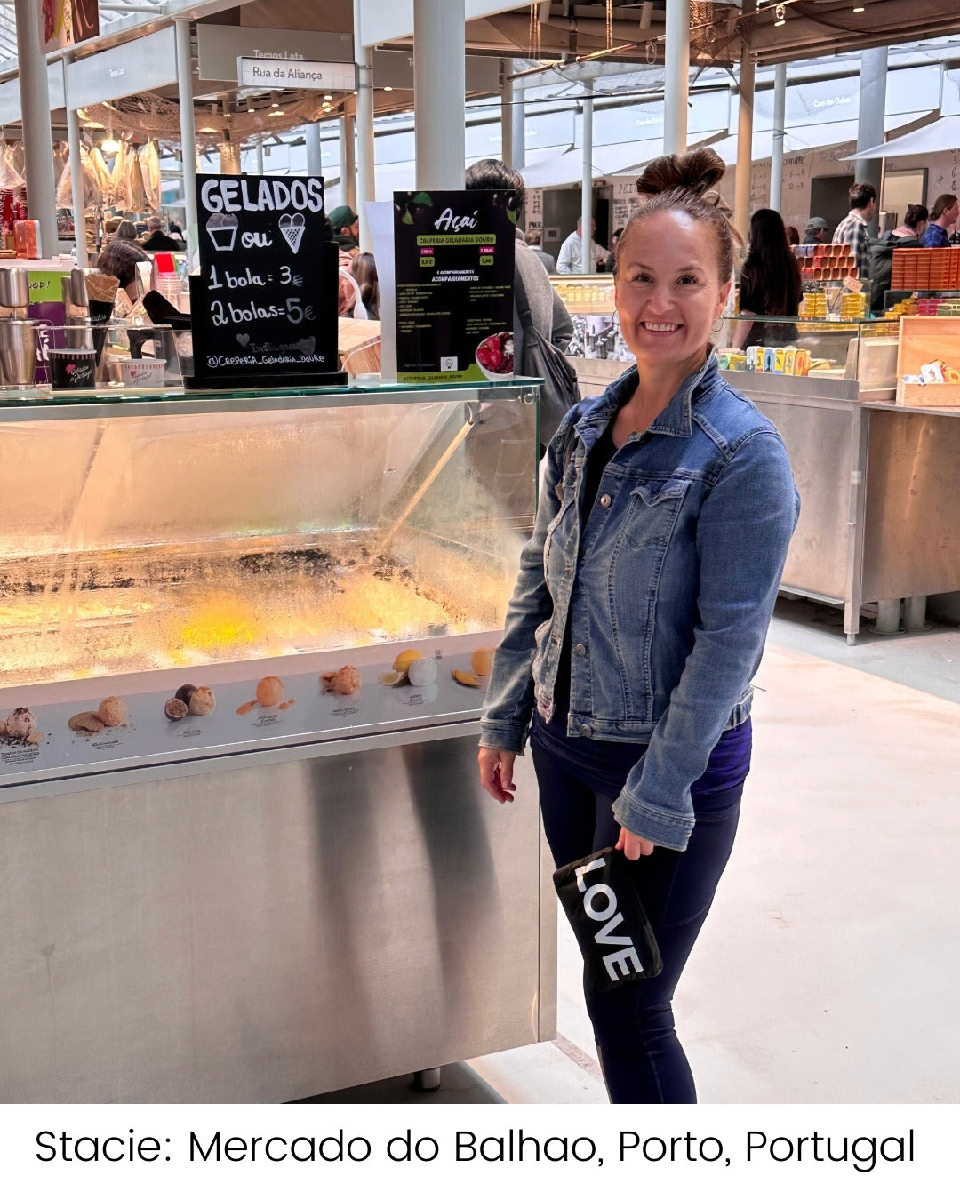 Woman standing by gelato stand holding black wristlet pouch with "LOVE."